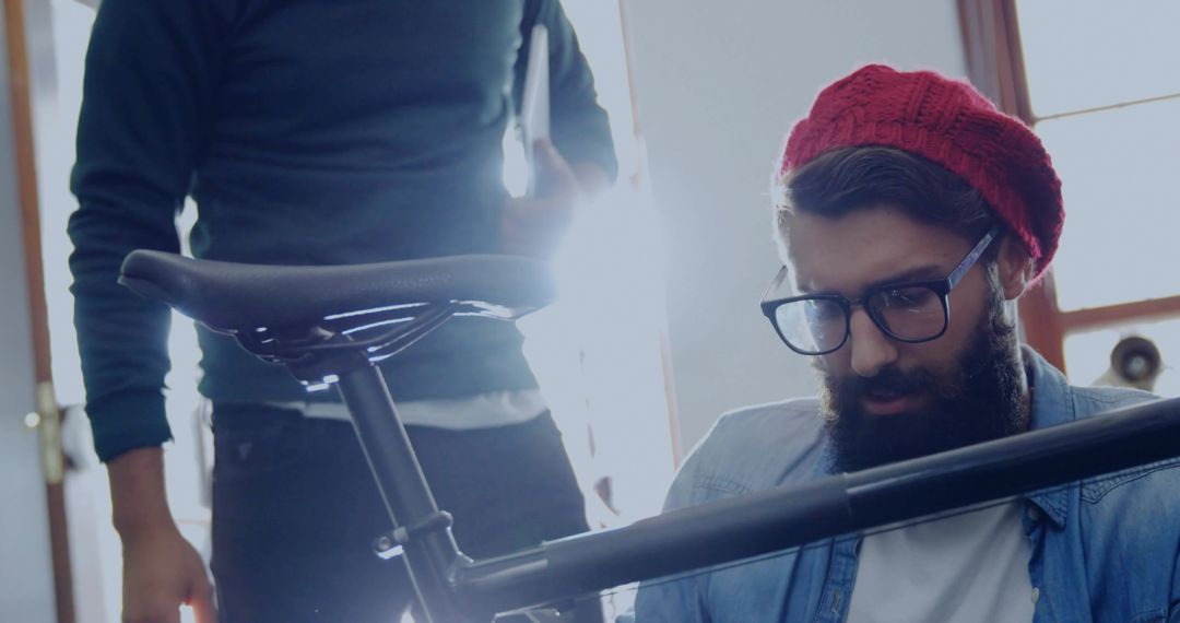 Kneeling Mechanic in Workshop Adjusting Bicycle Seat