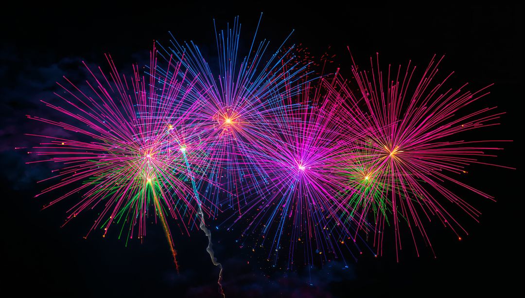 Vibrant fireworks bursting with vivid rainbow streaks and sparkling cores against dark sky