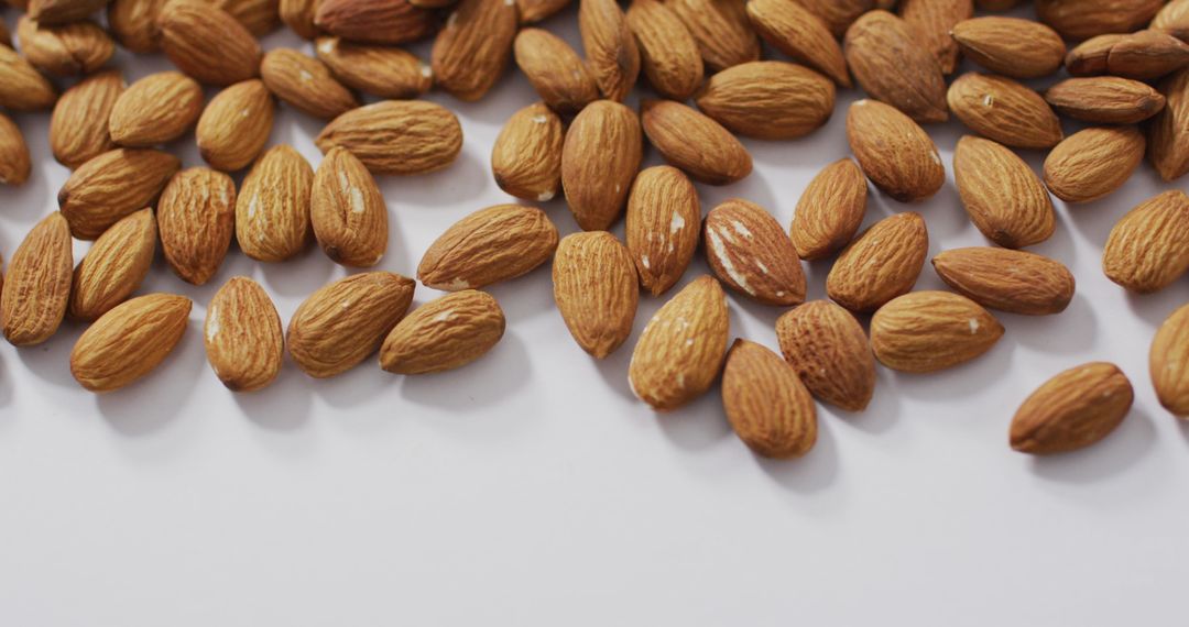 Scattered Almonds on White Background for Healthy Eating Concepts
