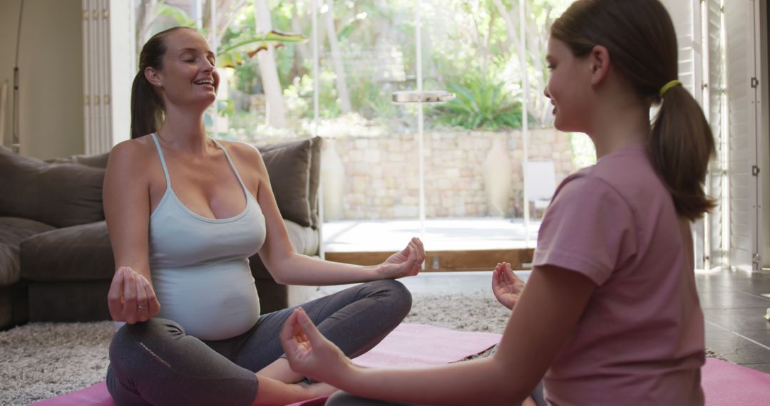 Pregnant woman meditating with daughter at home - Free Images, Stock Photos and Pictures on Pikwizard.com