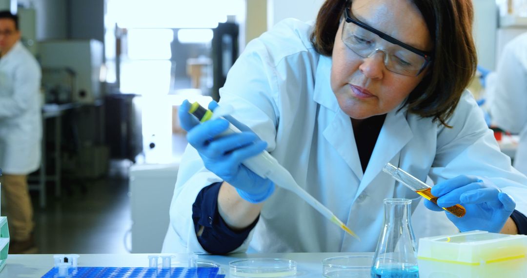 Female Scientist Conducting Laboratory Experiment with Pipette - Free Images, Stock Photos and Pictures on Pikwizard.com