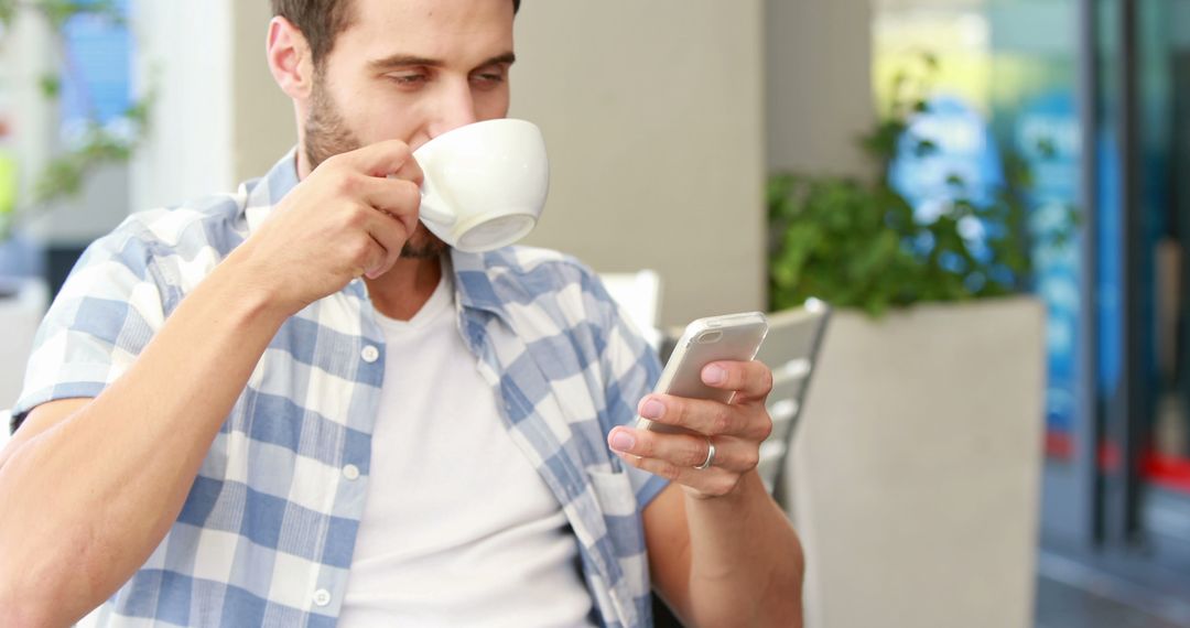 Young Man Drinking Coffee and Using Smartphone at Outdoor Cafe - Free Images, Stock Photos and Pictures on Pikwizard.com