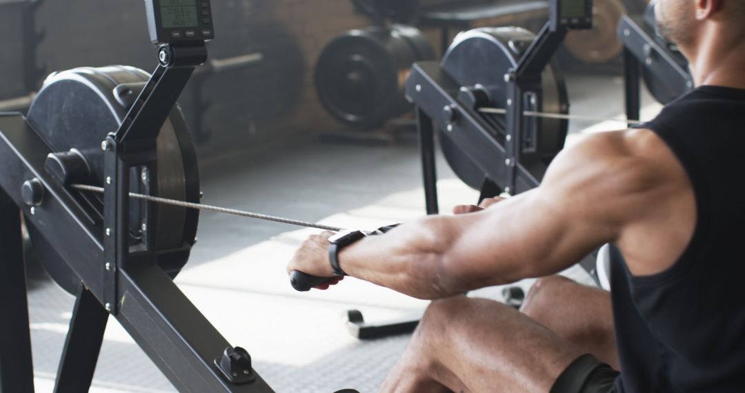 Man Using Rowing Machine for Fitness in Gym Environment
