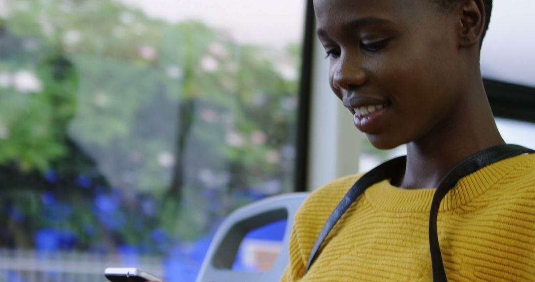 Woman Smiling While Looking at Smartphone on Bus - Free Images, Stock Photos and Pictures on Pikwizard.com