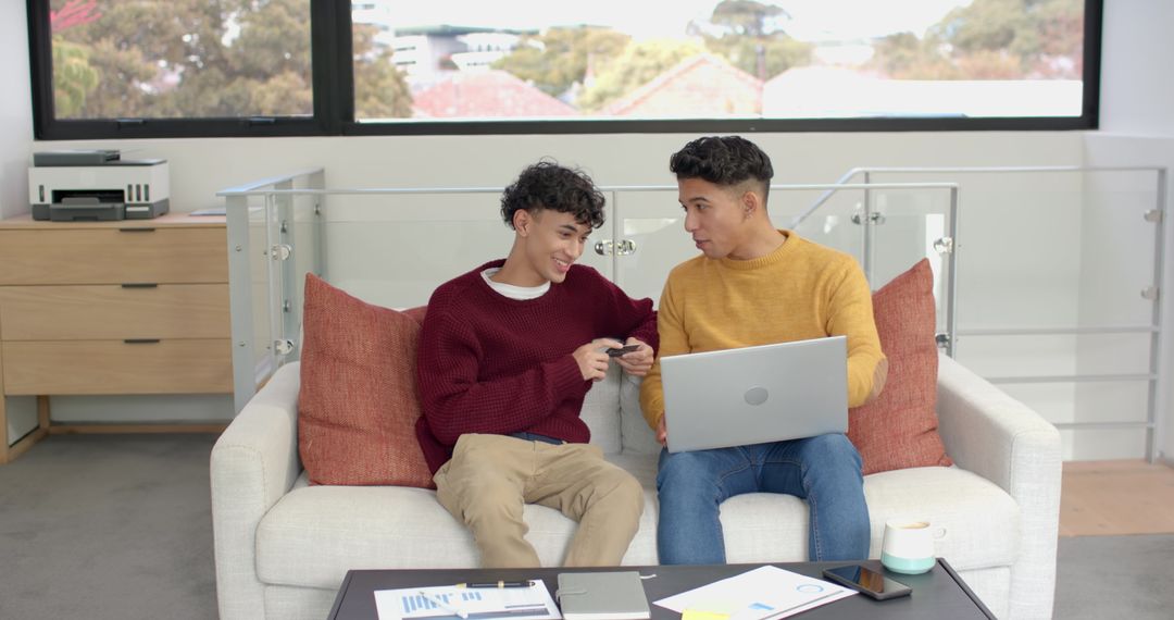 Male Colleagues Collaborating in Office Lounge Using Tech