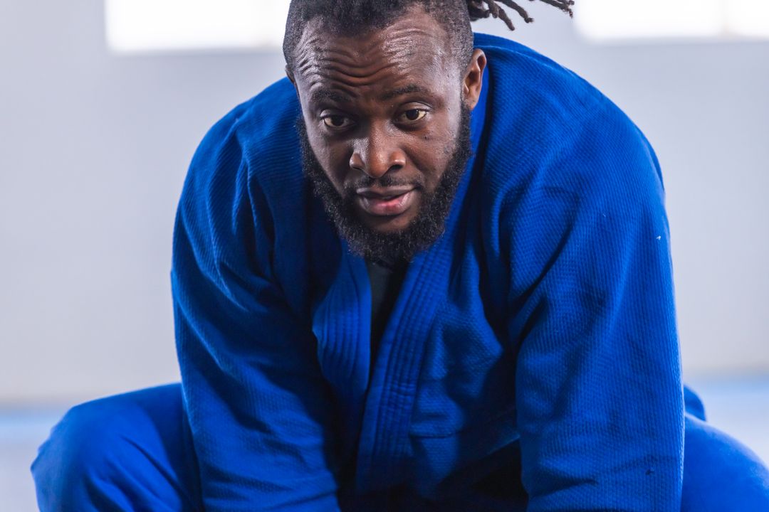 Martial Artist Practicing in Blue Gi on Padded Mat