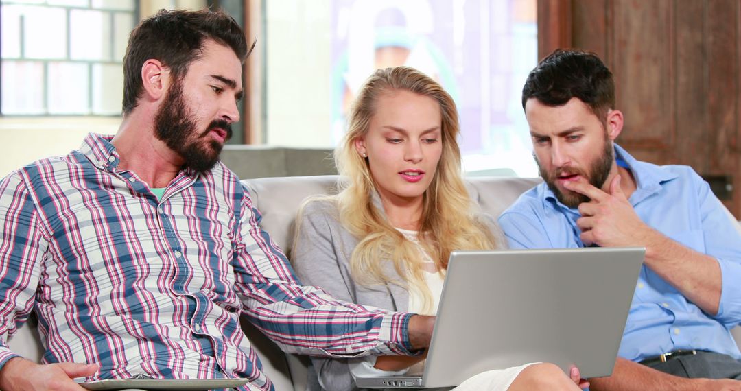 Diverse Team Collaborating on Laptop in Creative Office Space