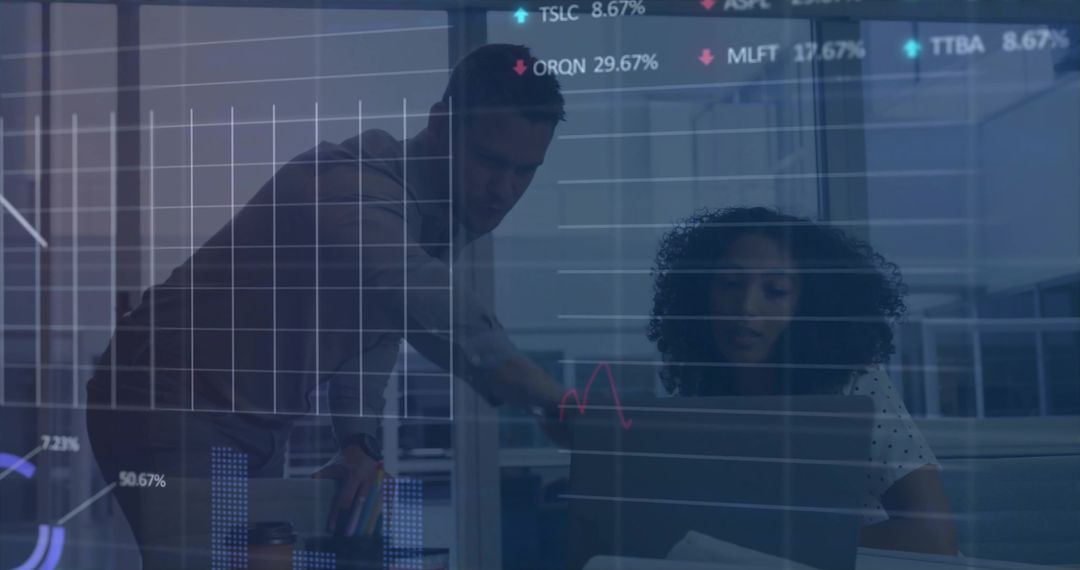 Colleagues analyzing interactive dashboards on laptop while collaborating in modern office