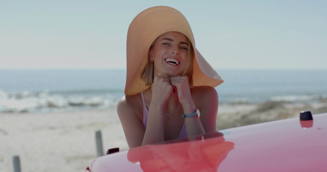 Woman Enjoying Beach Day by Red Convertible with Straw Hat