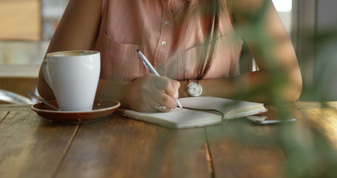 Woman Writing Notes in Journal Over Coffee at Cafe Table - Free Images, Stock Photos and Pictures on Pikwizard.com