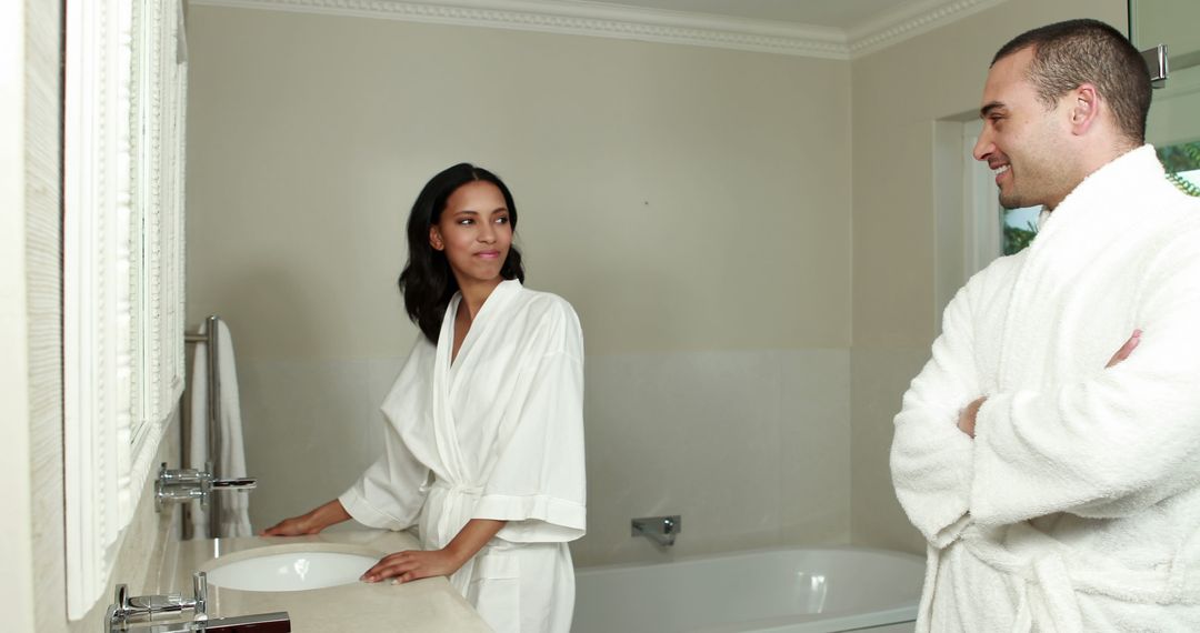 Couple in Bathroom Wearing White Robes Talking Smiling - Free Images, Stock Photos and Pictures on Pikwizard.com