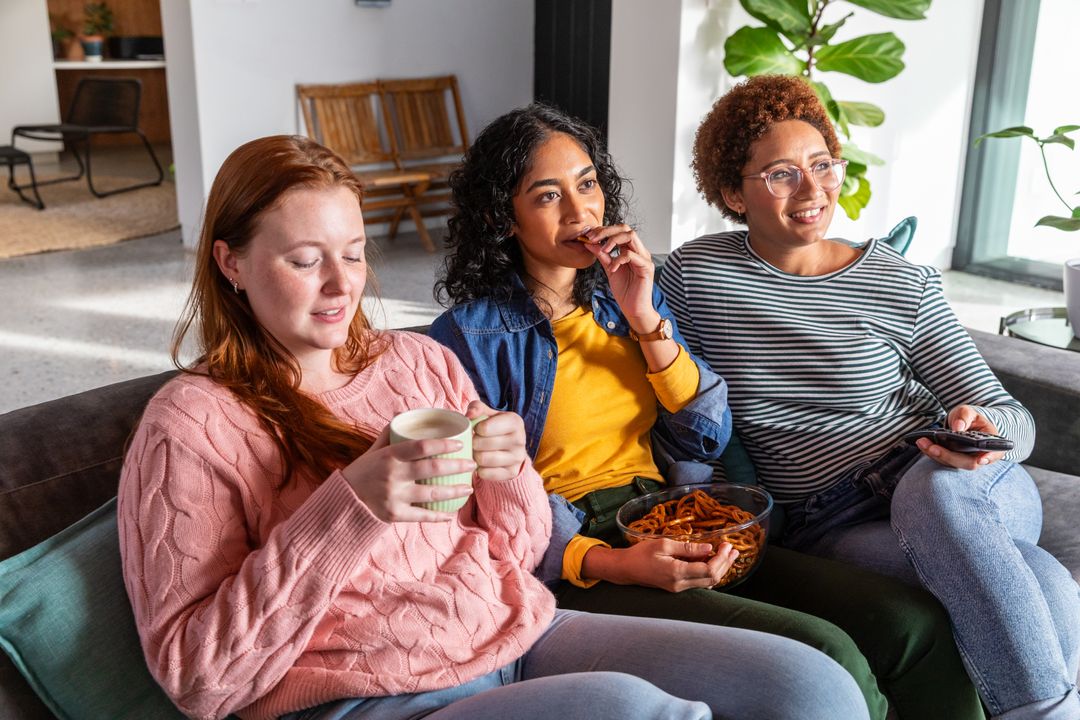 Casual Gathering of Diverse Friends Relaxing Indoors with Snacks
