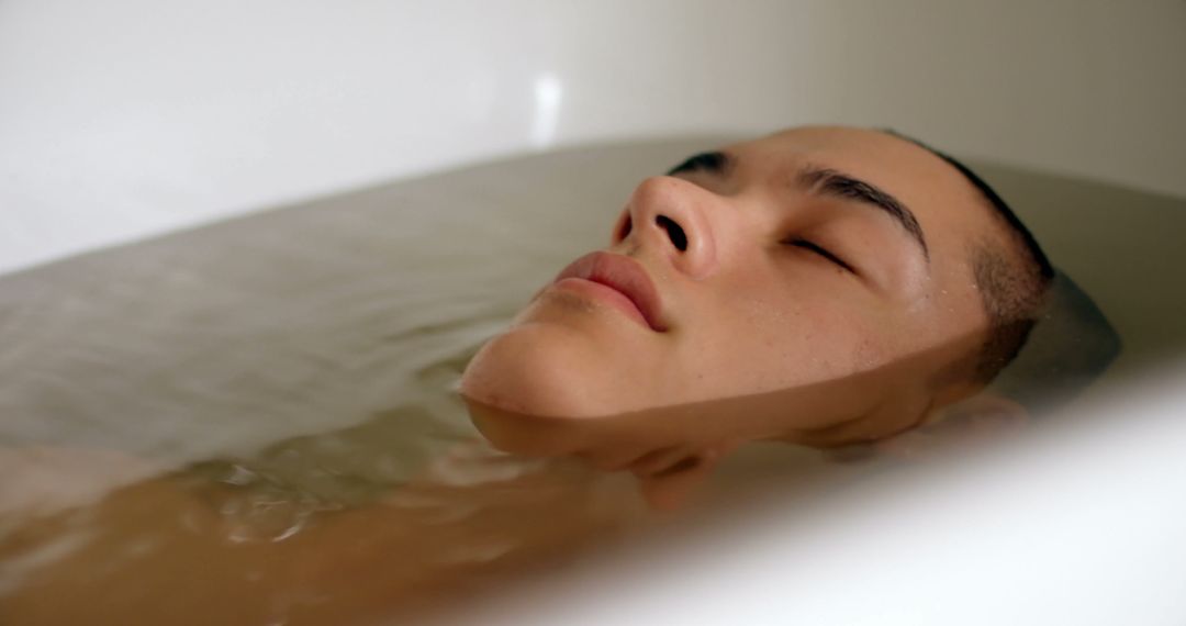 Young Person Relaxing in Bathtub with Eyes Closed - Free Images, Stock Photos and Pictures on Pikwizard.com