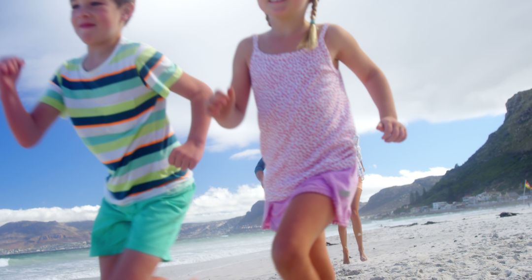 Children Running on Beach with Mountains in Background - Free Images, Stock Photos and Pictures on Pikwizard.com