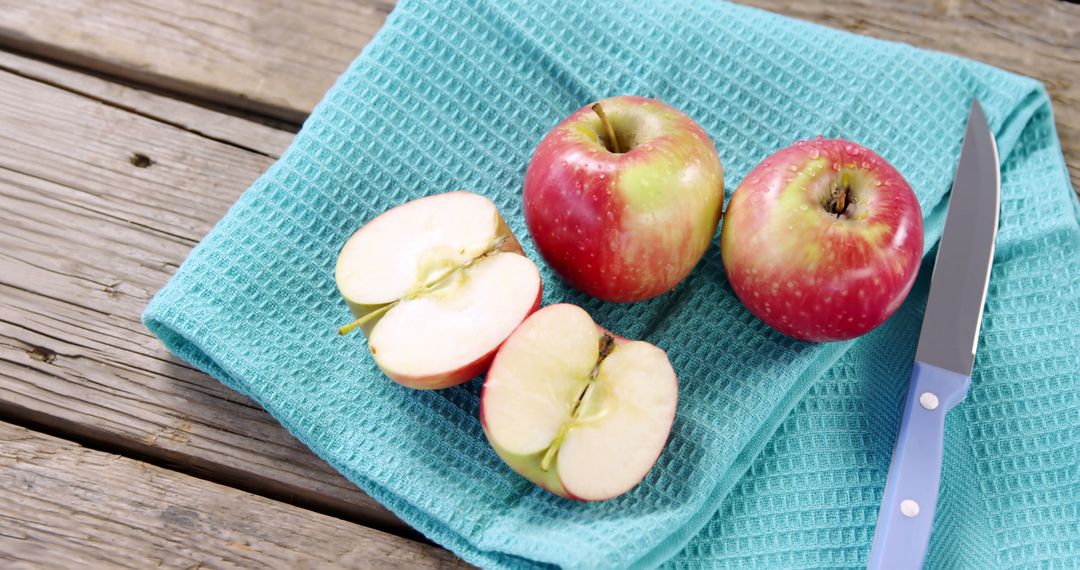Fresh Red Apples Sliced on Turquoise Cloth with Knife