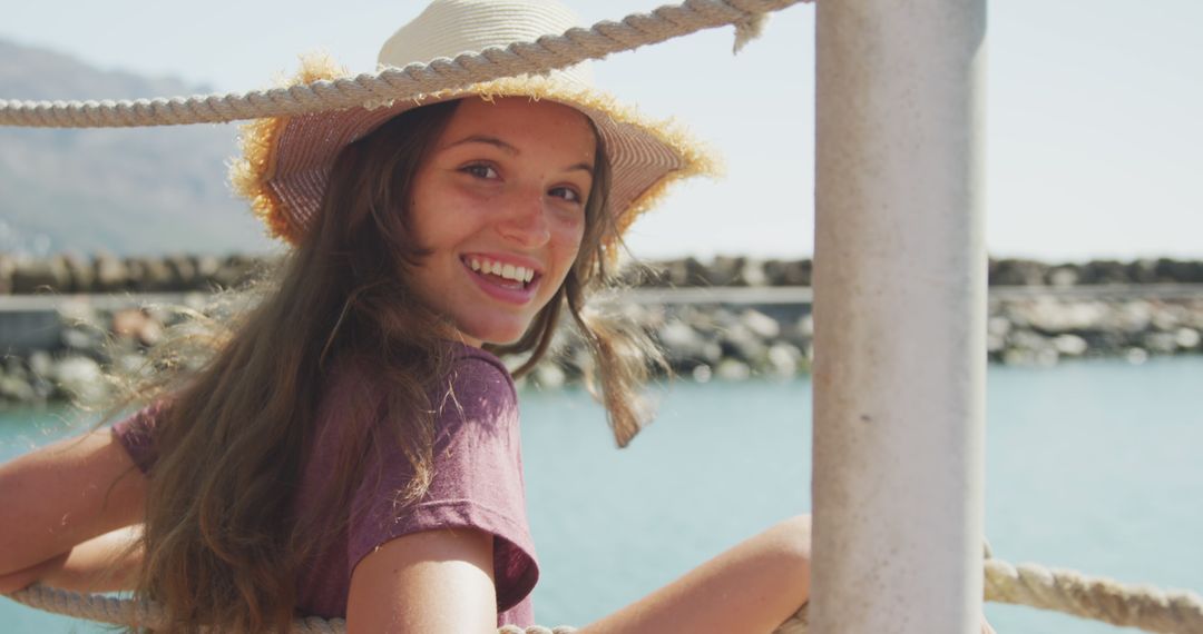 Smiling Young Woman Wearing Sun Hat by the Seaside - Free Images, Stock Photos and Pictures on Pikwizard.com