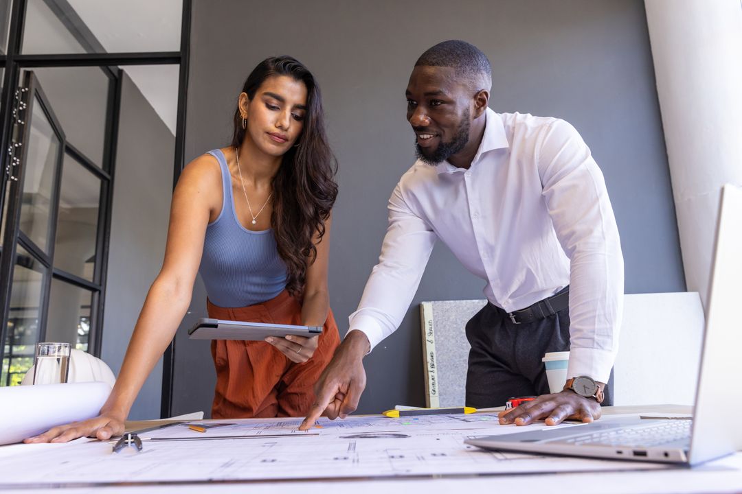 Diverse Professionals Discussing Blueprints in Modern Office