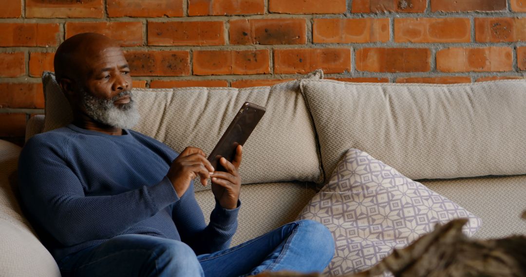 Senior Man Relaxing on Couch Using Tablet - Free Images, Stock Photos and Pictures on Pikwizard.com