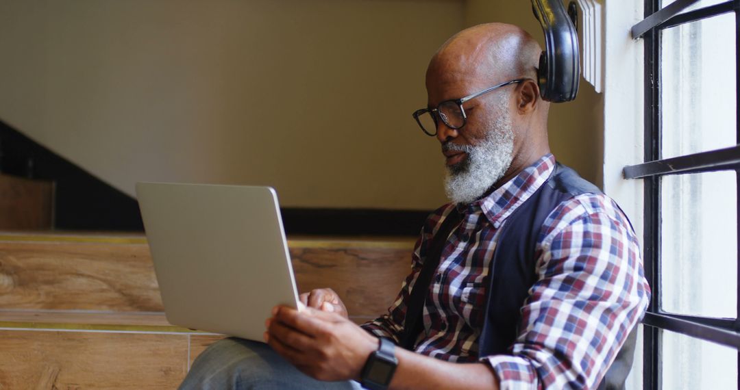 Mature Man with Beard Using Laptop in Cozy Corner - Free Images, Stock Photos and Pictures on Pikwizard.com