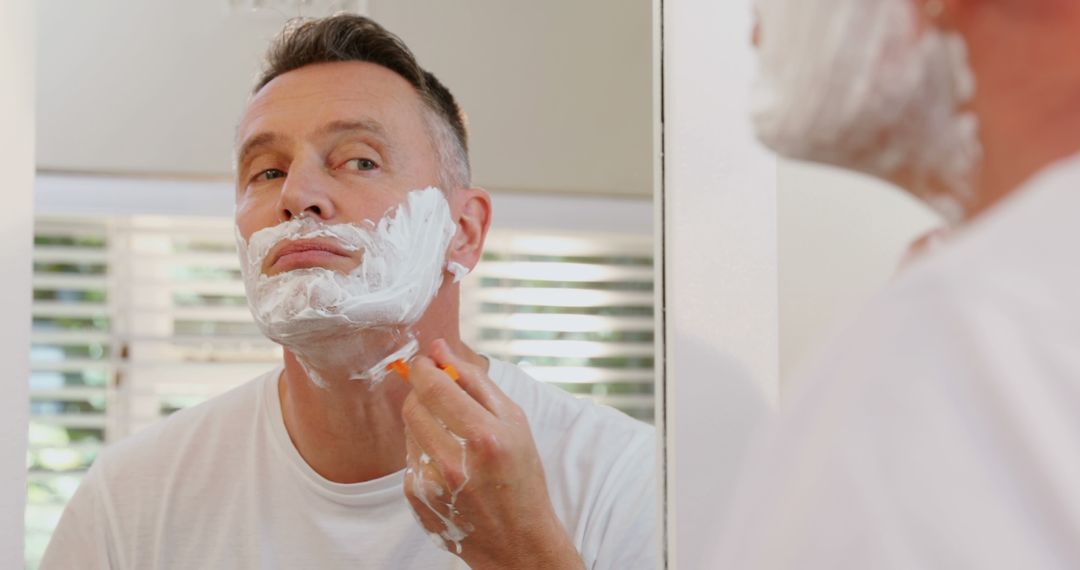 Middle-Aged Man Shaving in Front of Bathroom Mirror - Free Images, Stock Photos and Pictures on Pikwizard.com