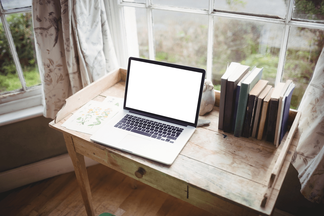 Transparent Laptop and Books Near Sunlit Window Table