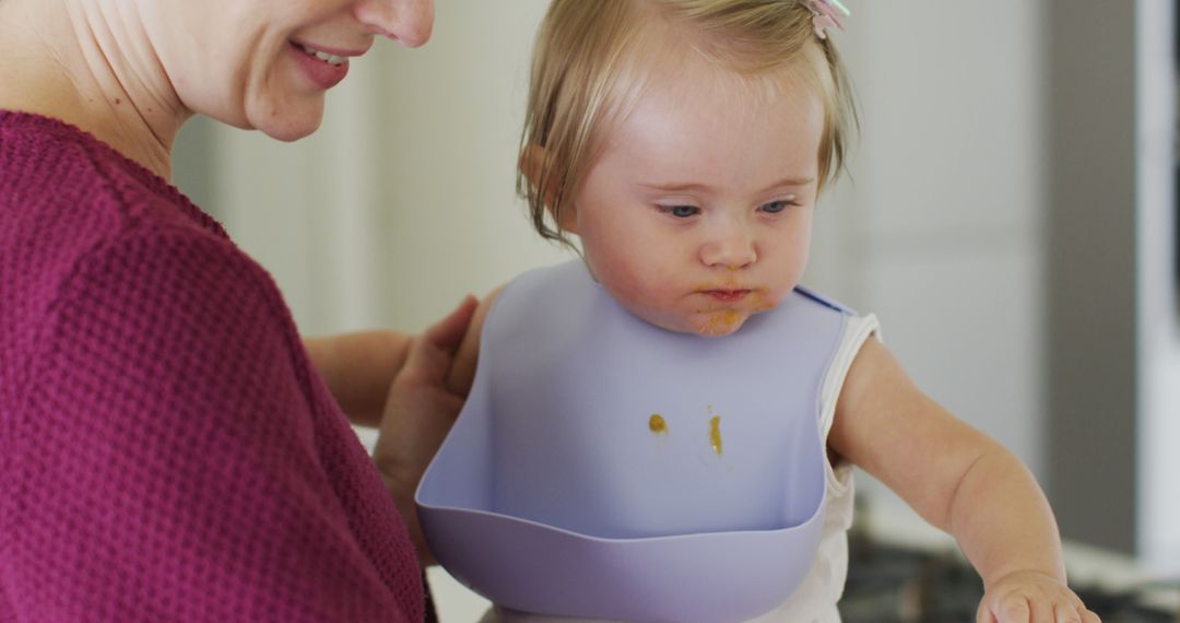 Mother Feeding Infant with Down Syndrome in Kitchen - Free Images, Stock Photos and Pictures on Pikwizard.com