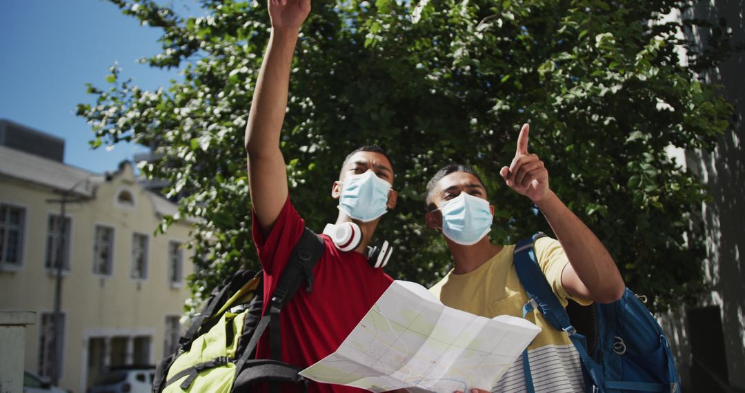 Two Male Friends Using Map in City During Pandemic