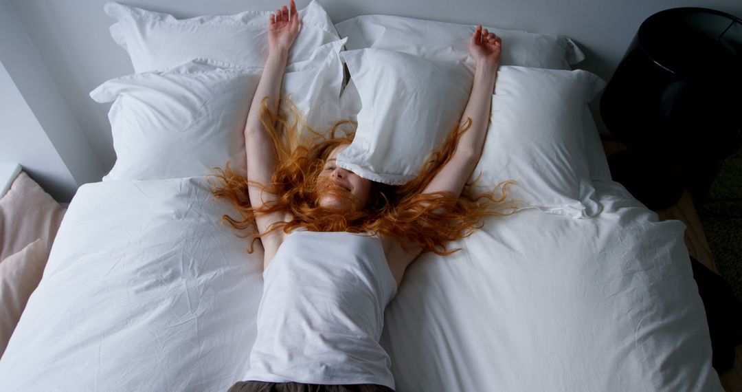 Woman Relaxing in Bed with Arms Stretched Out - Free Images, Stock Photos and Pictures on Pikwizard.com