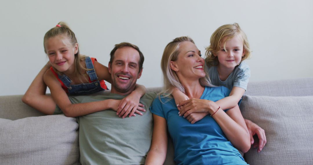 Happy Family Sitting on Sofa, Smiling and Relaxing Together - Free Images, Stock Photos and Pictures on Pikwizard.com