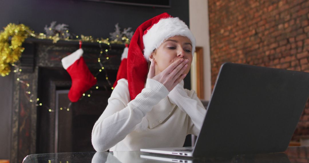 Woman Wearing Santa Hat Blowing Kiss During Video Call at Christmas - Free Images, Stock Photos and Pictures on Pikwizard.com