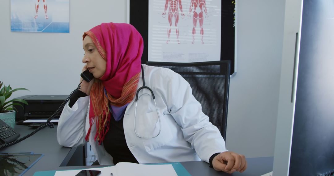 Female Doctor in Hijab Discussing Diagnosis on Phone in Office - Free Images, Stock Photos and Pictures on Pikwizard.com