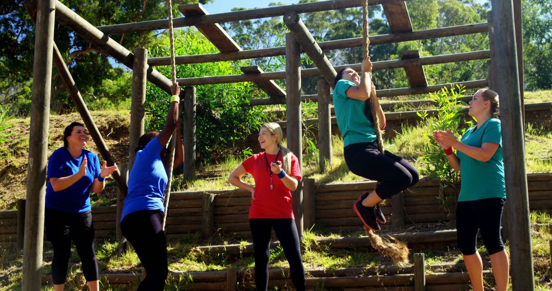 Group of friends encouraging woman on obstacle course outdoors - Free Images, Stock Photos and Pictures on Pikwizard.com