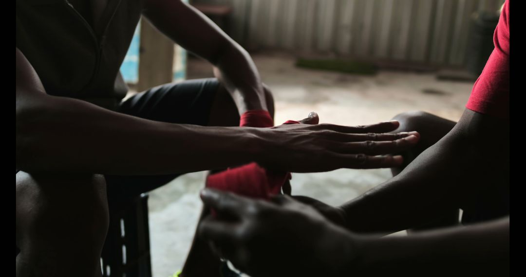 Trainer Wrapping Boxer's Hands in Gym Before Training