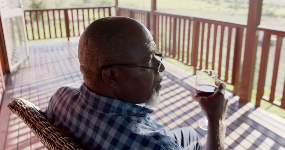 Mature Man Relaxing with Wine on Porch - Free Images, Stock Photos and Pictures on Pikwizard.com