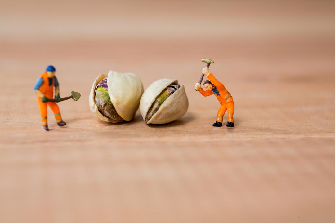 Miniature construction workers with pistachio nuts - Free Images, Stock Photos and Pictures on Pikwizard.com