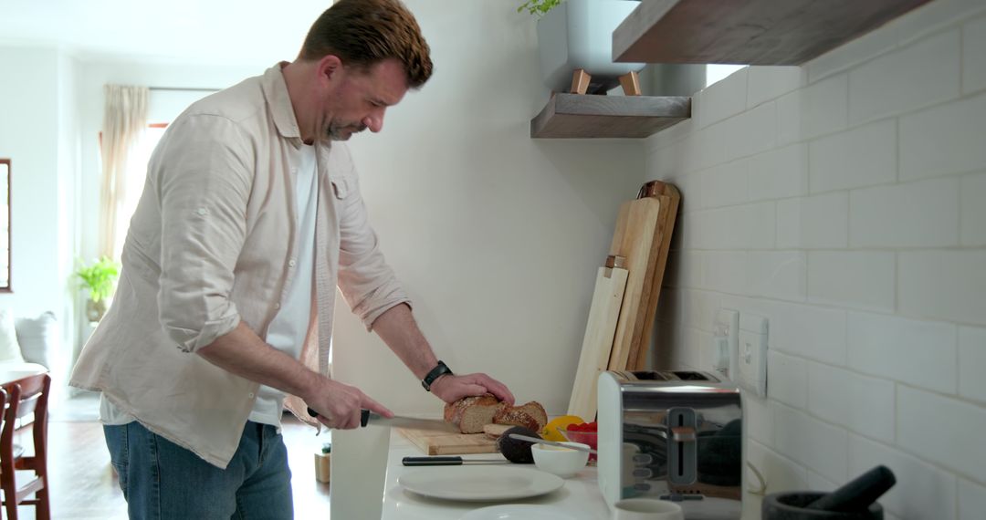 Adult Man Slicing Multigrain Bread in Minimalist Kitchen