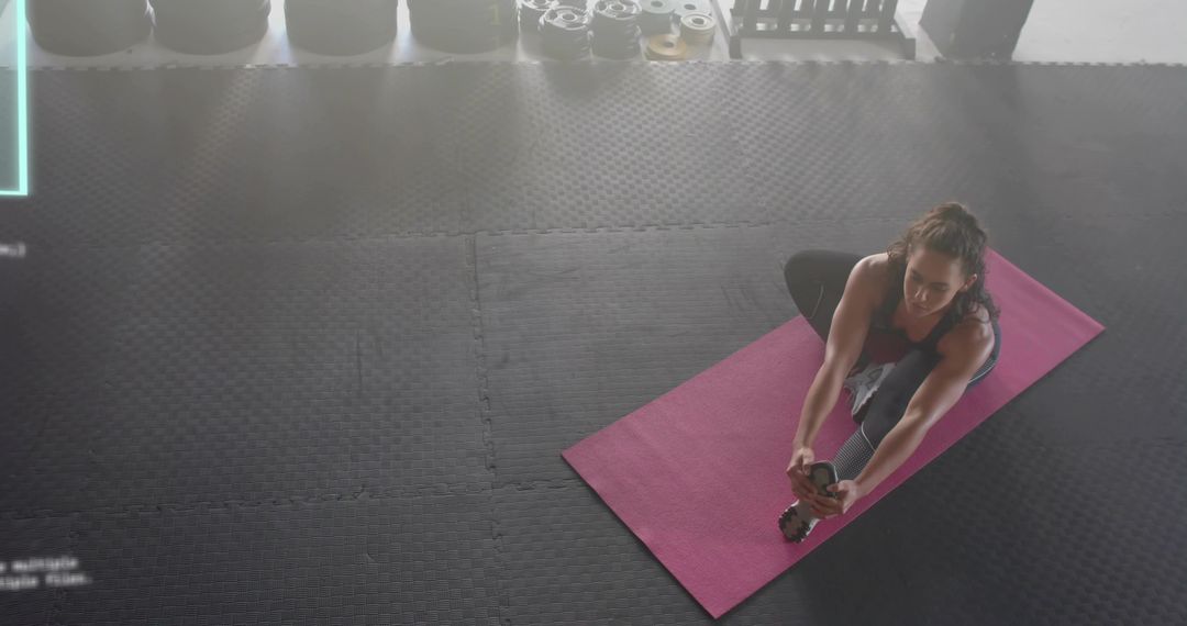 Woman Stretching on Pink Mat in Gym Practicing Seated Forward Bend for Flexibility
