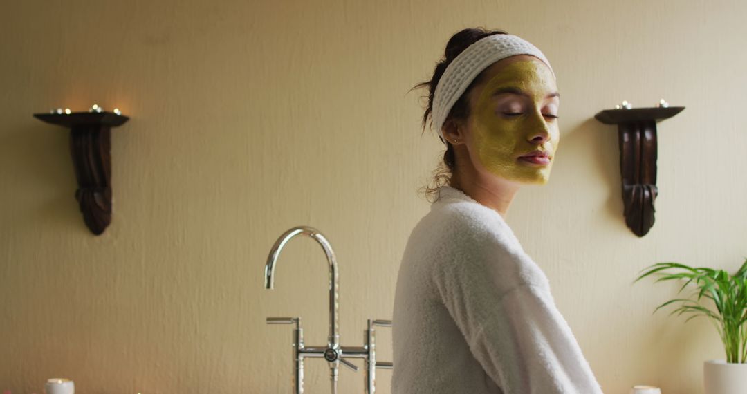 Woman with Green Face Mask Smiling During Skincare Routine at Home