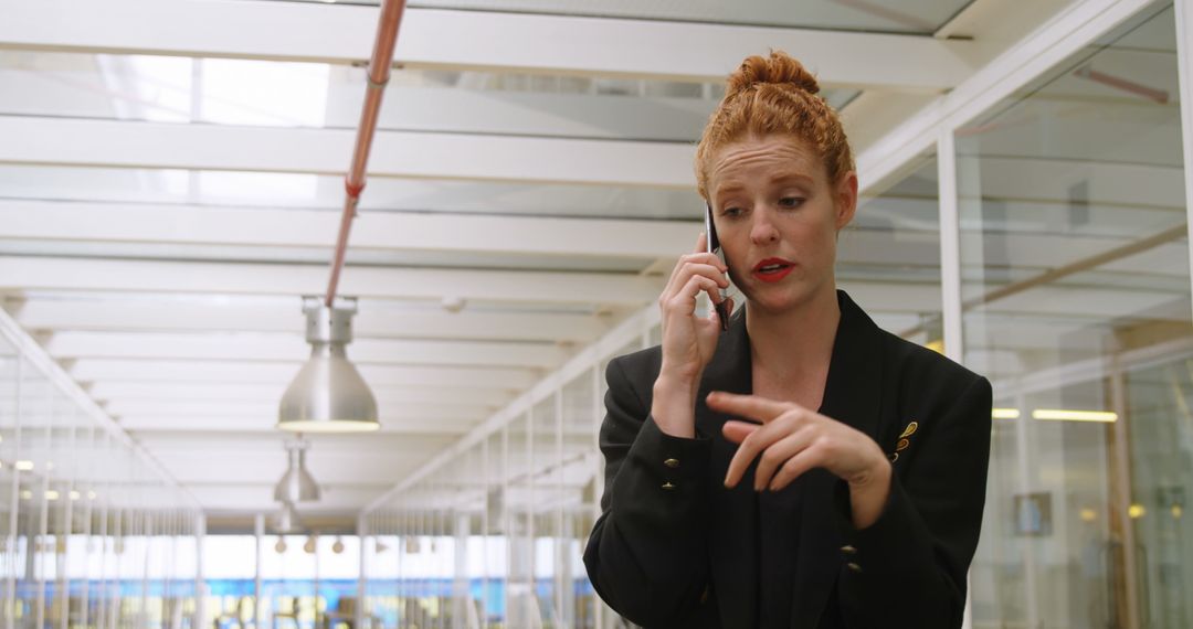 Confident businesswoman talking on phone in modern office corridor - Free Images, Stock Photos and Pictures on Pikwizard.com