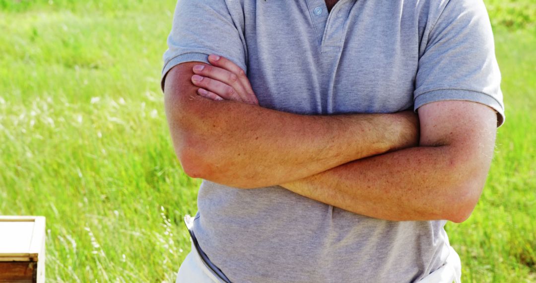 Man Crossing Arms Standing in Field - Free Images, Stock Photos and Pictures on Pikwizard.com