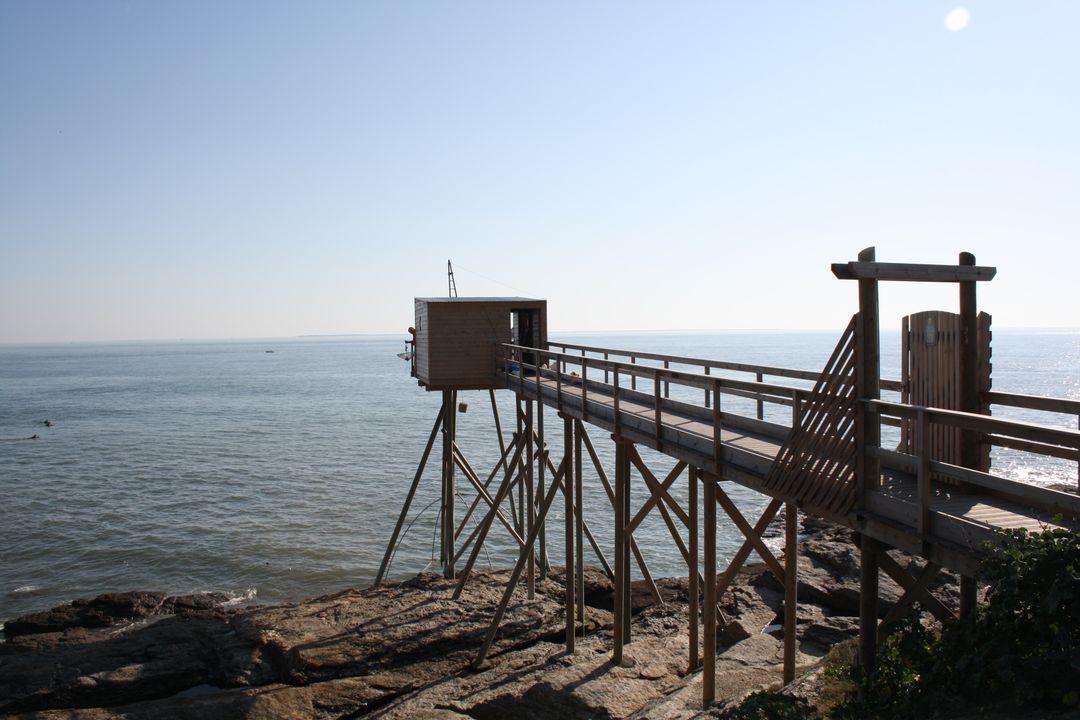 Scenic fishing hut on stilts over rocky coastline during clear day - Free Images, Stock Photos and Pictures on Pikwizard.com