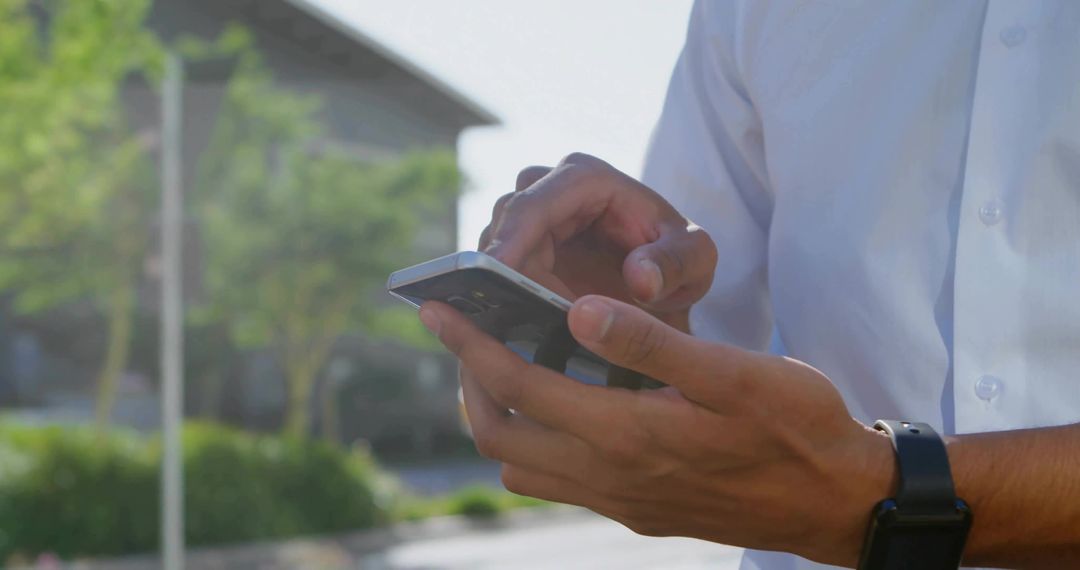 Man Using Smartphone Outdoors in Professional Attire