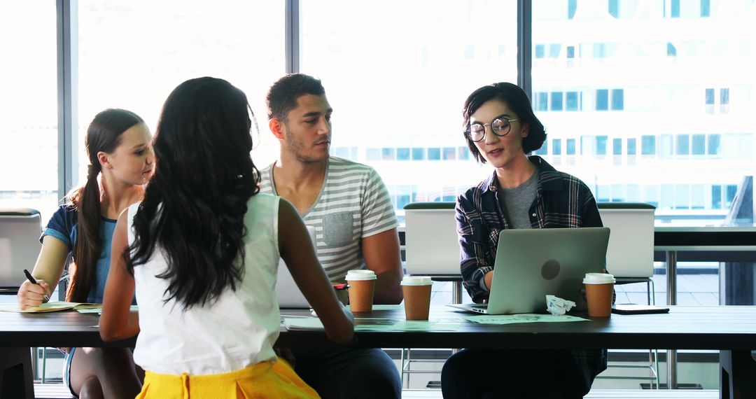 Young Diverse Professionals Discussing Ideas in Modern Office Setting