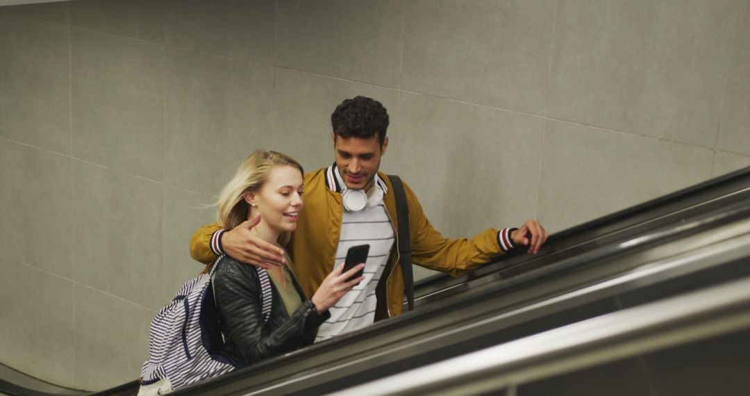 Couple Smiling and Using Smartphone on Escalator - Free Images, Stock Photos and Pictures on Pikwizard.com