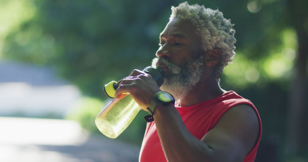 African american senior man exercising outdoors drinking from water bottle in street - Free Images, Stock Photos and Pictures on Pikwizard.com