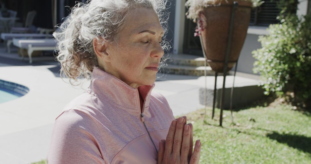 Senior Woman Meditating Outdoors in Sunlit Garden - Free Images, Stock Photos and Pictures on Pikwizard.com