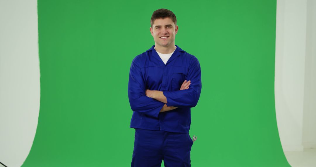 Smiling Worker in Blue Uniform Standing in Front of Green Screen - Free Images, Stock Photos and Pictures on Pikwizard.com