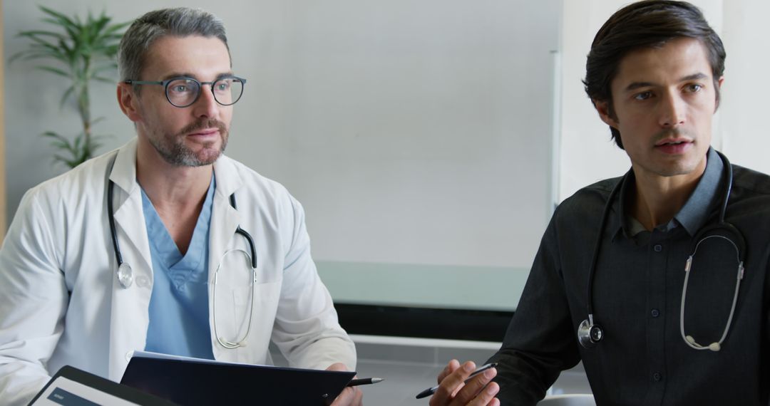 Two Doctors Discussing Medical Reports in Office - Free Images, Stock Photos and Pictures on Pikwizard.com