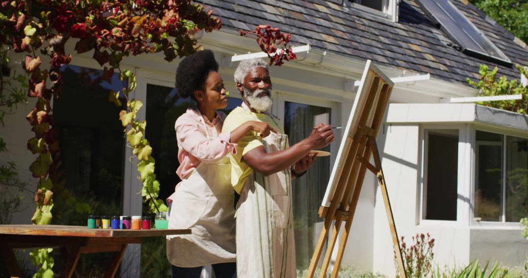 African american couple talking in sunny garden man painting picture on a canvas - Free Images, Stock Photos and Pictures on Pikwizard.com