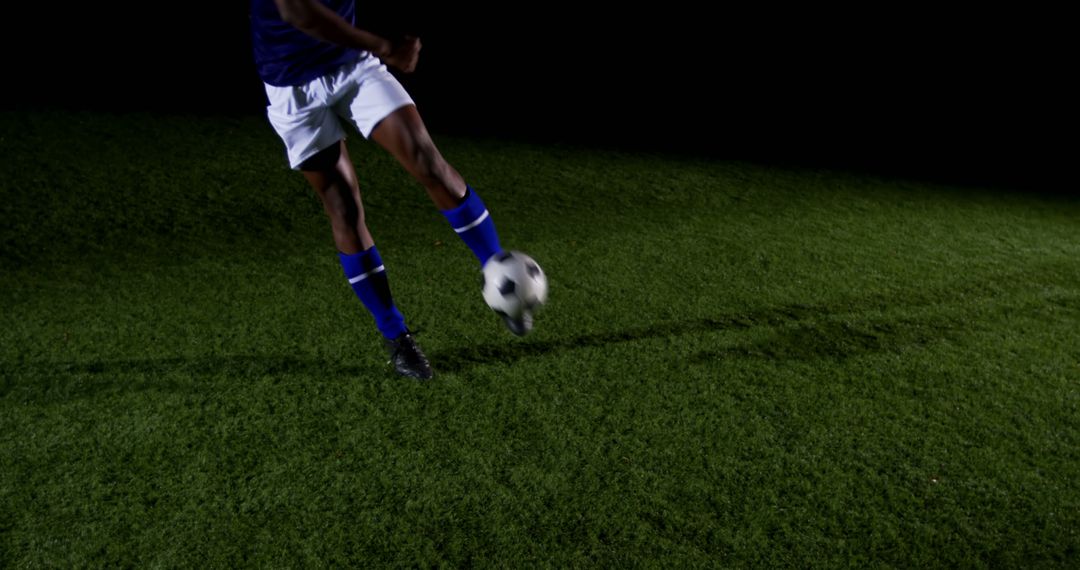 Soccer Player Kicking Ball on Grass Field at Night - Free Images, Stock Photos and Pictures on Pikwizard.com